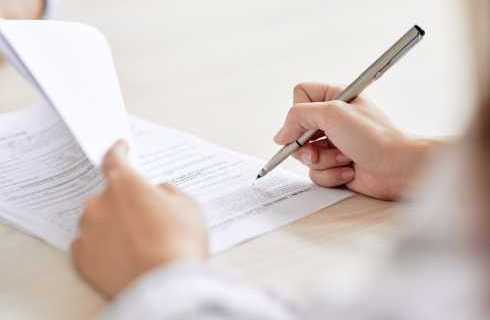 person signing contract with a pen